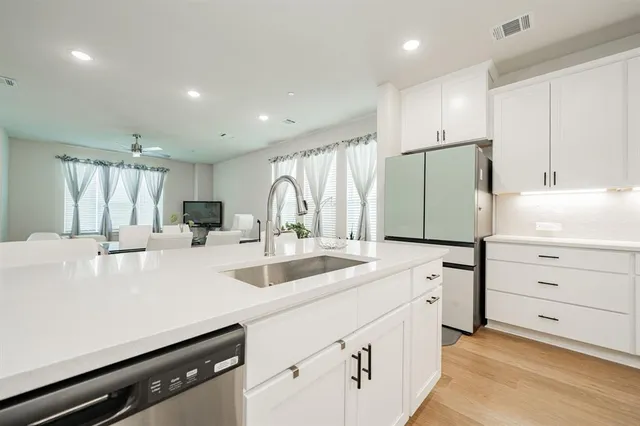 a kitchen with appliances a sink and cabinets