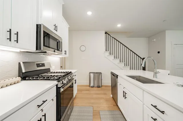 a kitchen with granite countertop a sink stove and cabinets