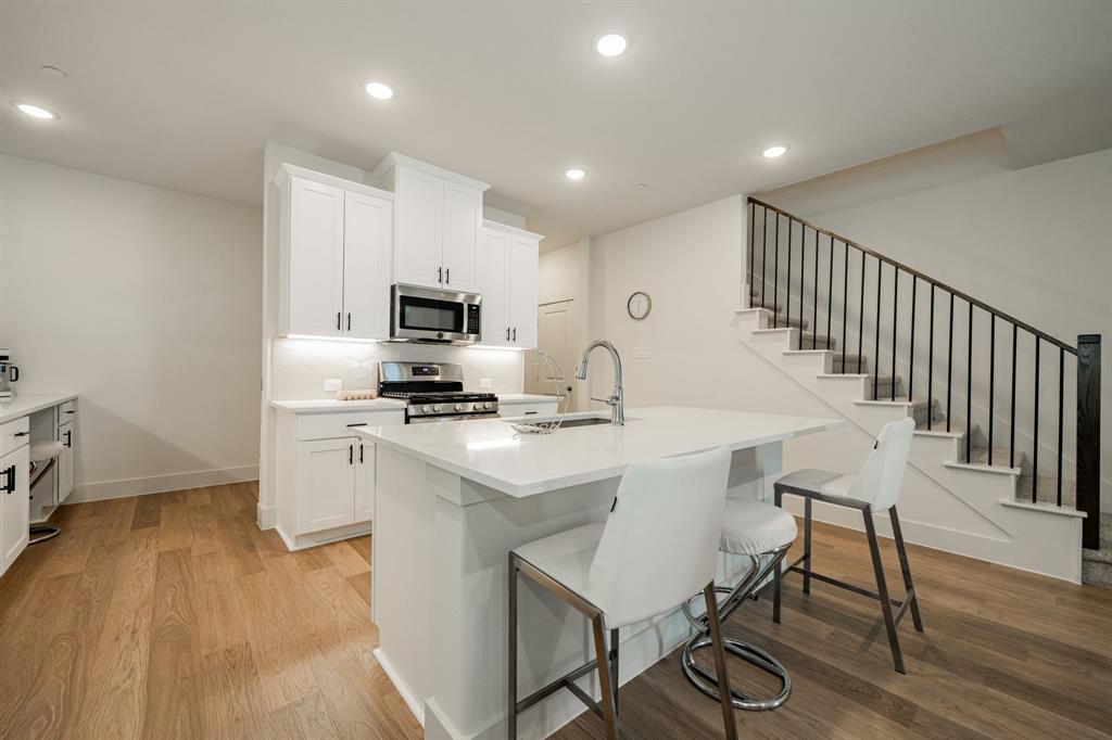 1416 Solterra Boulevard Mesquite, TX 75181 - Photo 14 of 32 a kitchen with a table chairs refrigerator and microwave