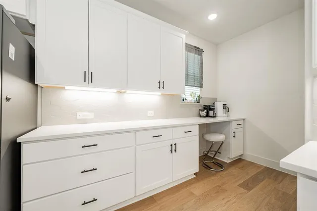 a kitchen with a table chairs refrigerator and microwave