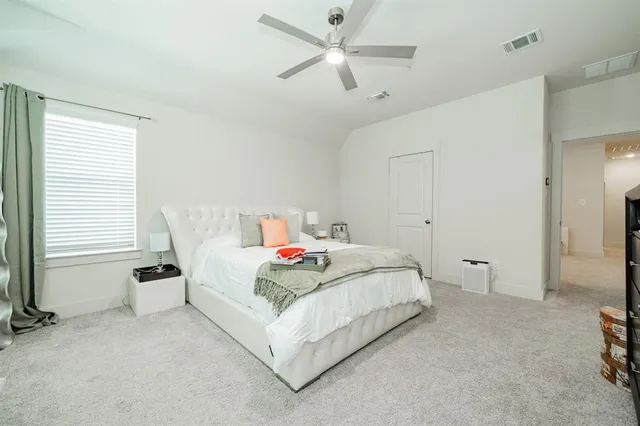 a bedroom with a bed and a ceiling fan