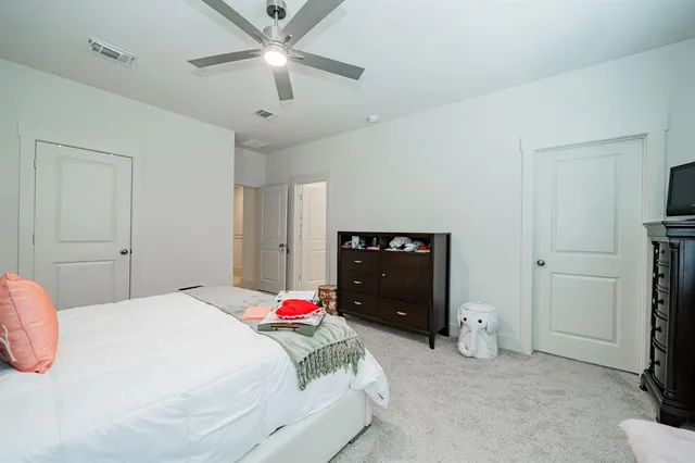 a bedroom with a bed and a ceiling fan