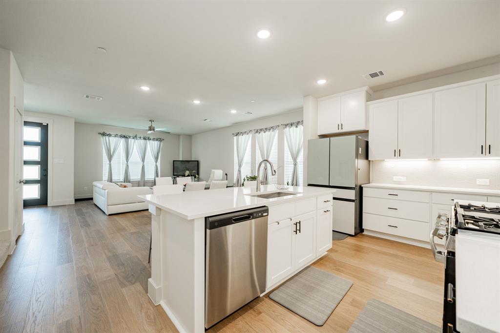 1416 Solterra Boulevard Mesquite, TX 75181 - Photo 9 of 32 a kitchen with a sink a stove a refrigerator and white cabinets