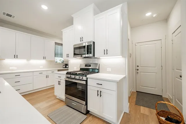a kitchen with cabinets stainless steel appliances and sink