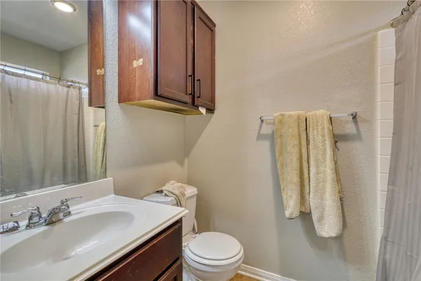 a bathroom with a sink vanity mirror and toilet