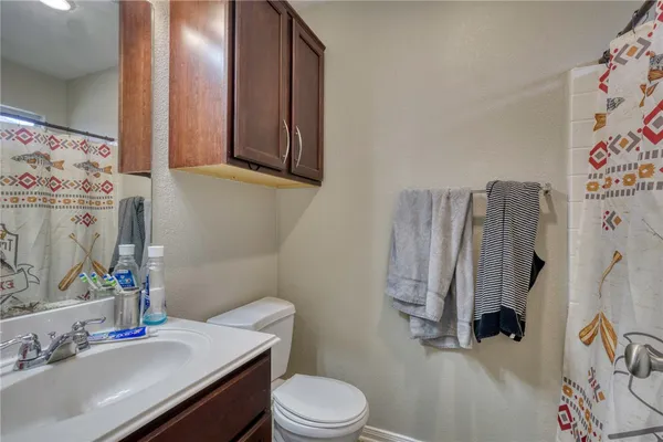 a bathroom with a sink toilet and mirror