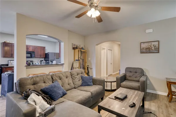a living room with furniture and view of kitchen