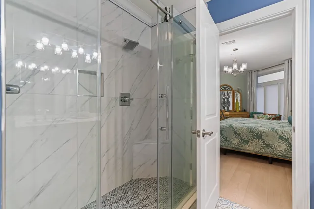 a bedroom with a bed and a chandelier