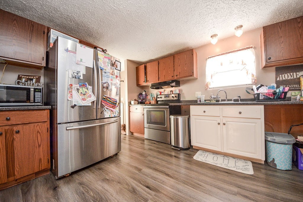 1261 Keith Valley Road Southeast Cleveland, TN 37323 - Photo 9 of 24 a kitchen with a refrigerator stove and wooden floor