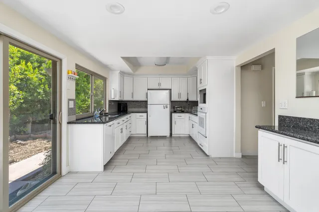 a kitchen with white cabinets and white appliances