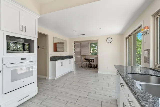 a kitchen with granite countertop a sink a stove and cabinets