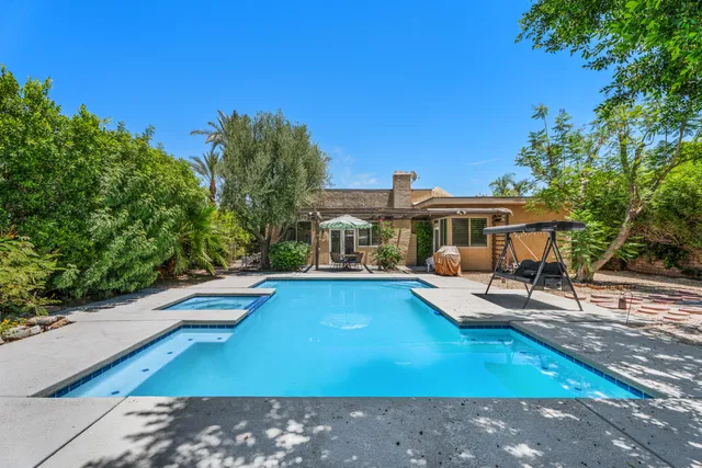 a view of house with swimming pool outdoor seating