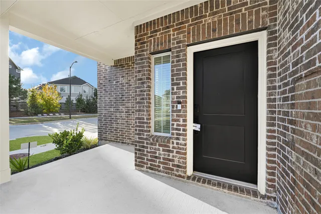 a view of a brick house with flower plants