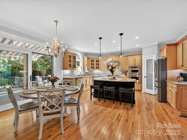 a view of a dining room with furniture a chandelier and wooden floor