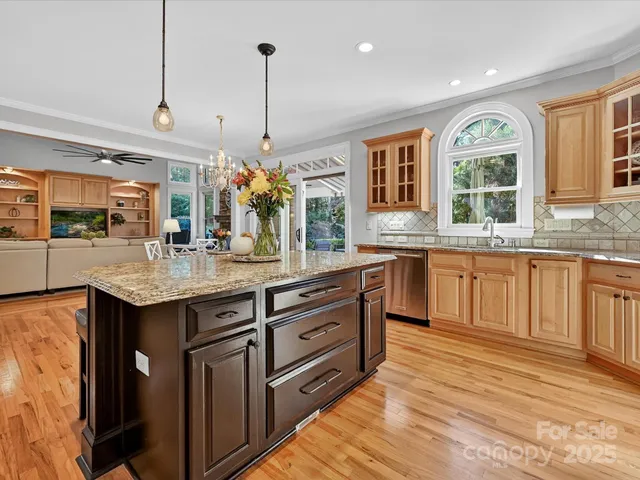 a kitchen with kitchen island granite countertop a stove and large window