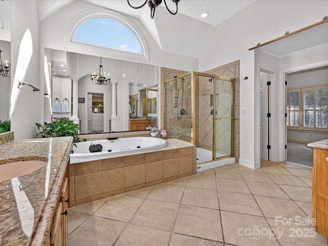 a large spacious bathroom with a granite countertop sink a mirror and bathtub