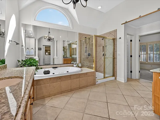 a large spacious bathroom with a granite countertop sink a mirror and bathtub