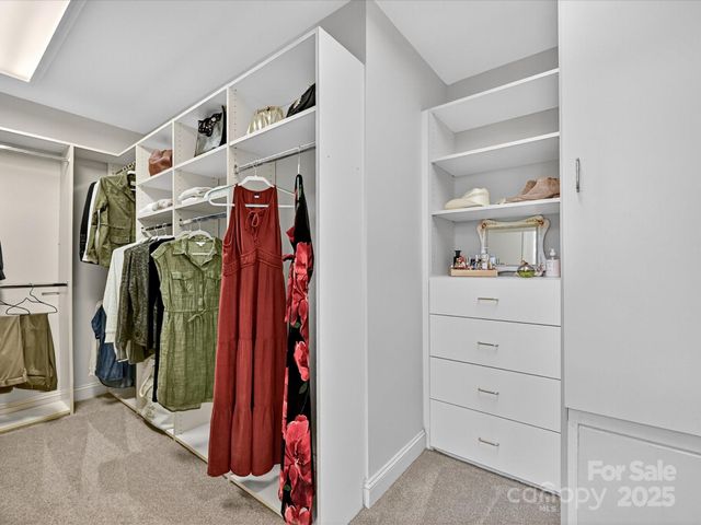 a view of walk in closet with clothes