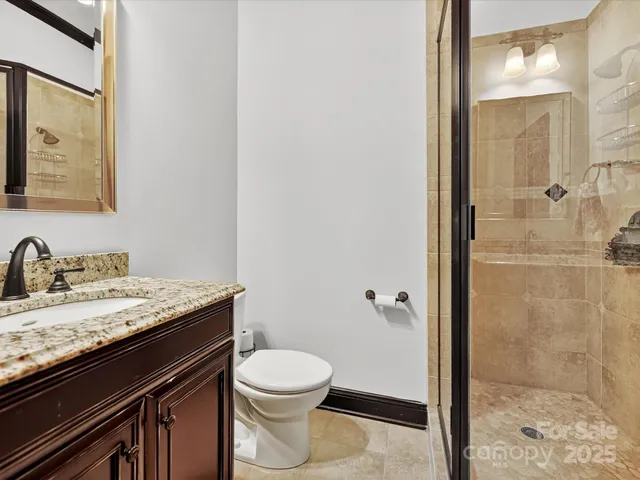 a bathroom with a granite countertop sink toilet and shower