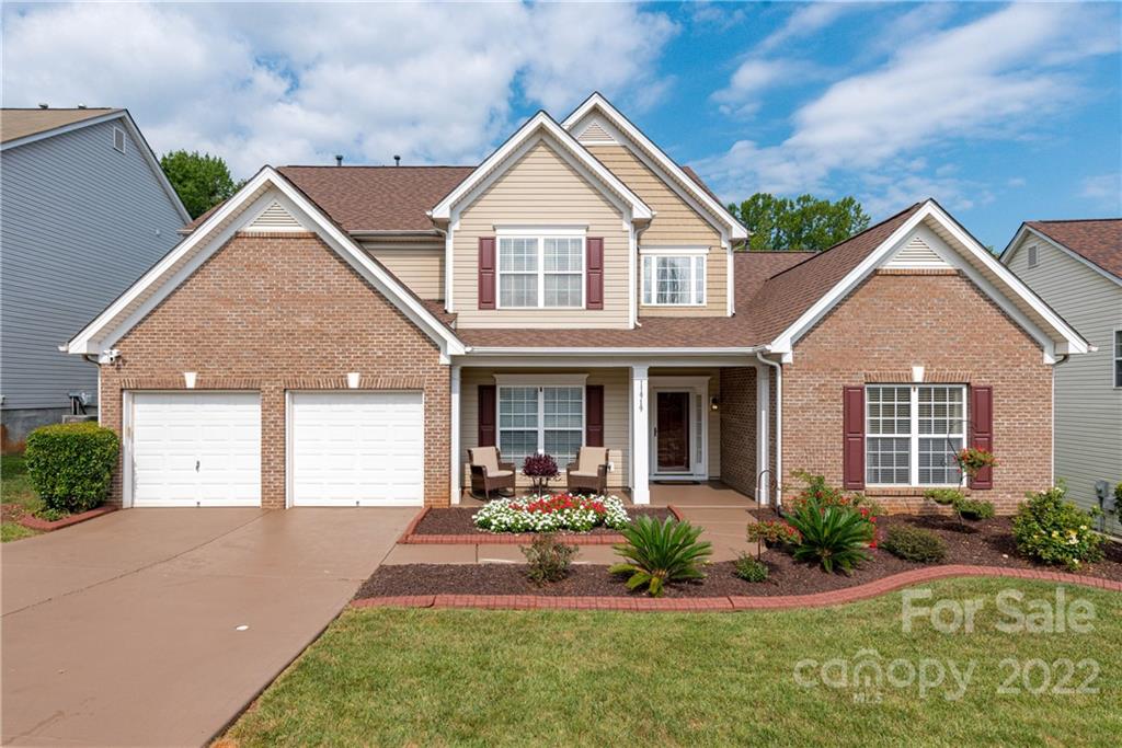 a front view of a house with a yard and potted plants