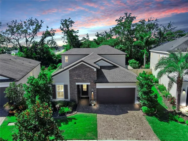 a front view of a house with a yard and mountain view
