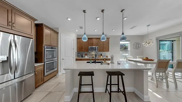 a kitchen with stainless steel appliances granite countertop a sink a stove and a wooden floors