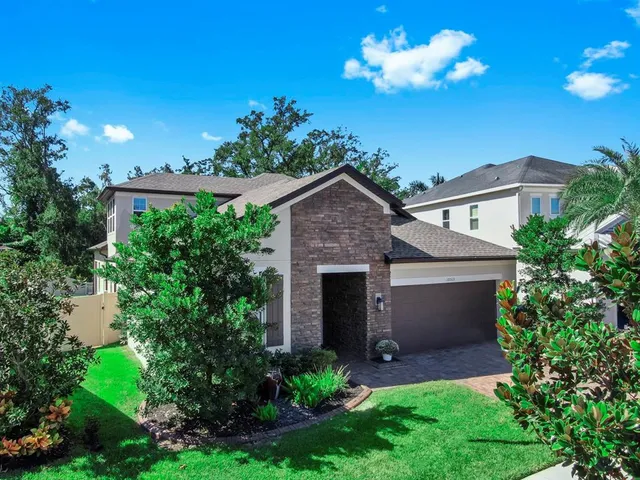 a front view of a house with a yard and potted plants