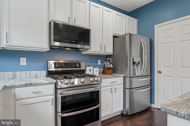 a bedroom with a bed a flat screen tv and a chandelier