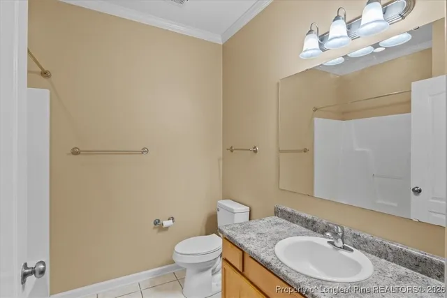 a bathroom with a granite countertop sink a mirror and a toilet