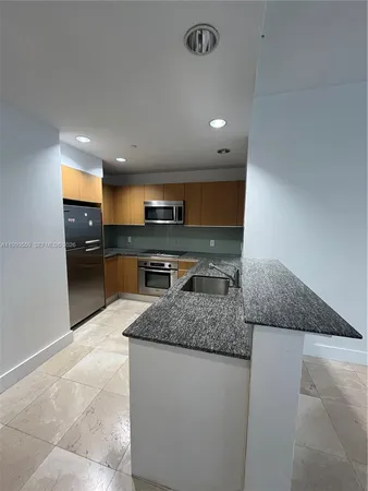 a kitchen with stainless steel appliances granite countertop a sink and a stove