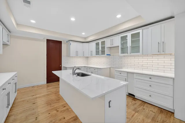a kitchen with a sink a stove and cabinets