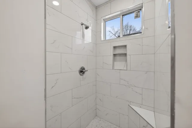 a bathroom with mirror and a shower