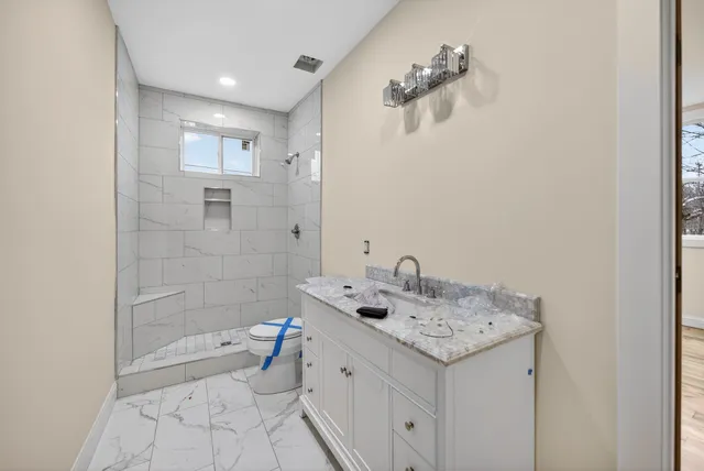 a bathroom with a sink a toilet and shower