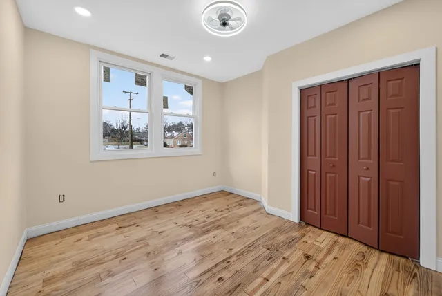 a view of empty room with wooden floor