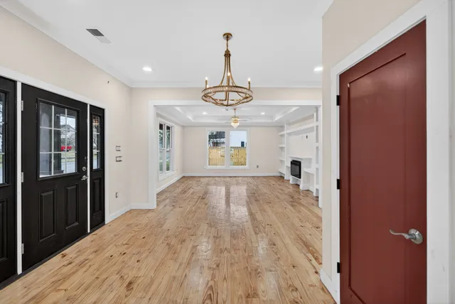 a view of empty room with wooden floor and window
