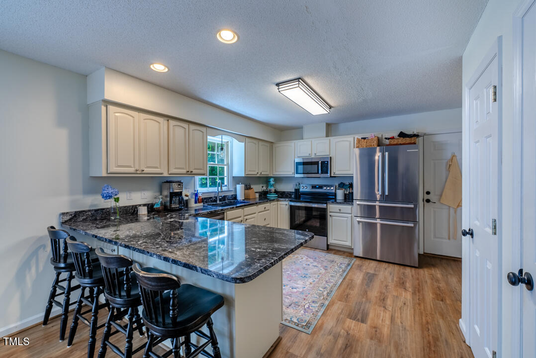 6806 Calais Drive Durham, NC 27712 - Photo 12 of 31 a kitchen with refrigerator and microwave