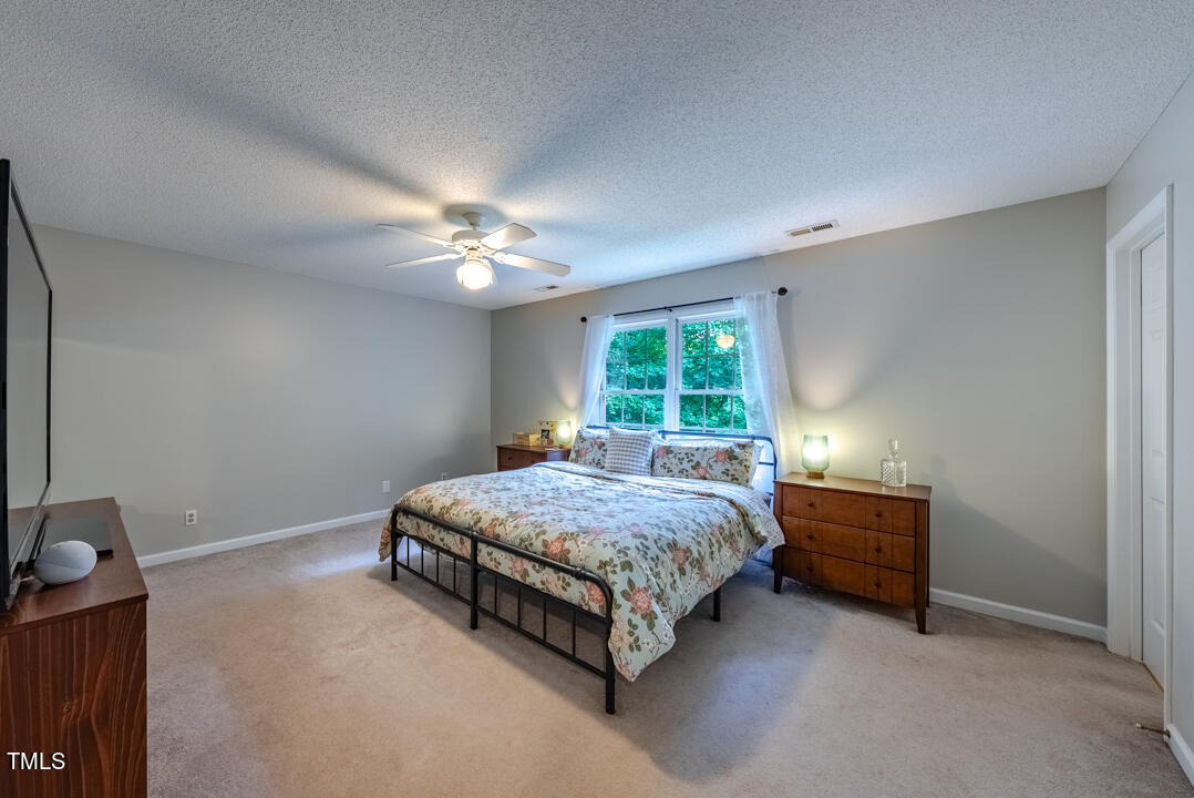 6806 Calais Drive Durham, NC 27712 - Photo 18 of 31 a bed sitting in a bedroom next to a window