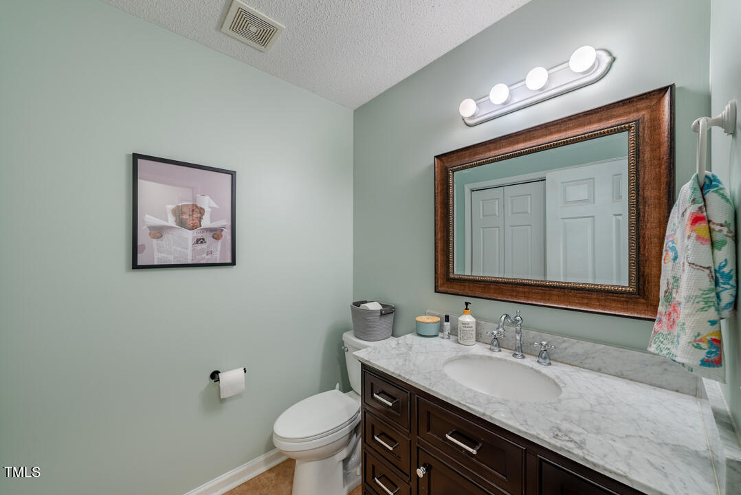 6806 Calais Drive Durham, NC 27712 - Photo 24 of 31 a bathroom with a granite countertop sink and a mirror