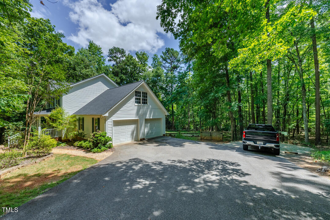 6806 Calais Drive Durham, NC 27712 - Photo 28 of 31 a view of a house with a small yard plants and large tree