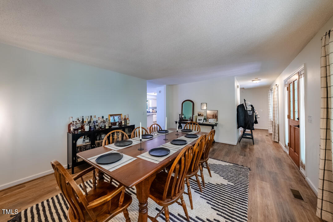 6806 Calais Drive Durham, NC 27712 - Photo 9 of 31 a view of a dining room and livingroom with furniture wooden floor a rug and a chandelier