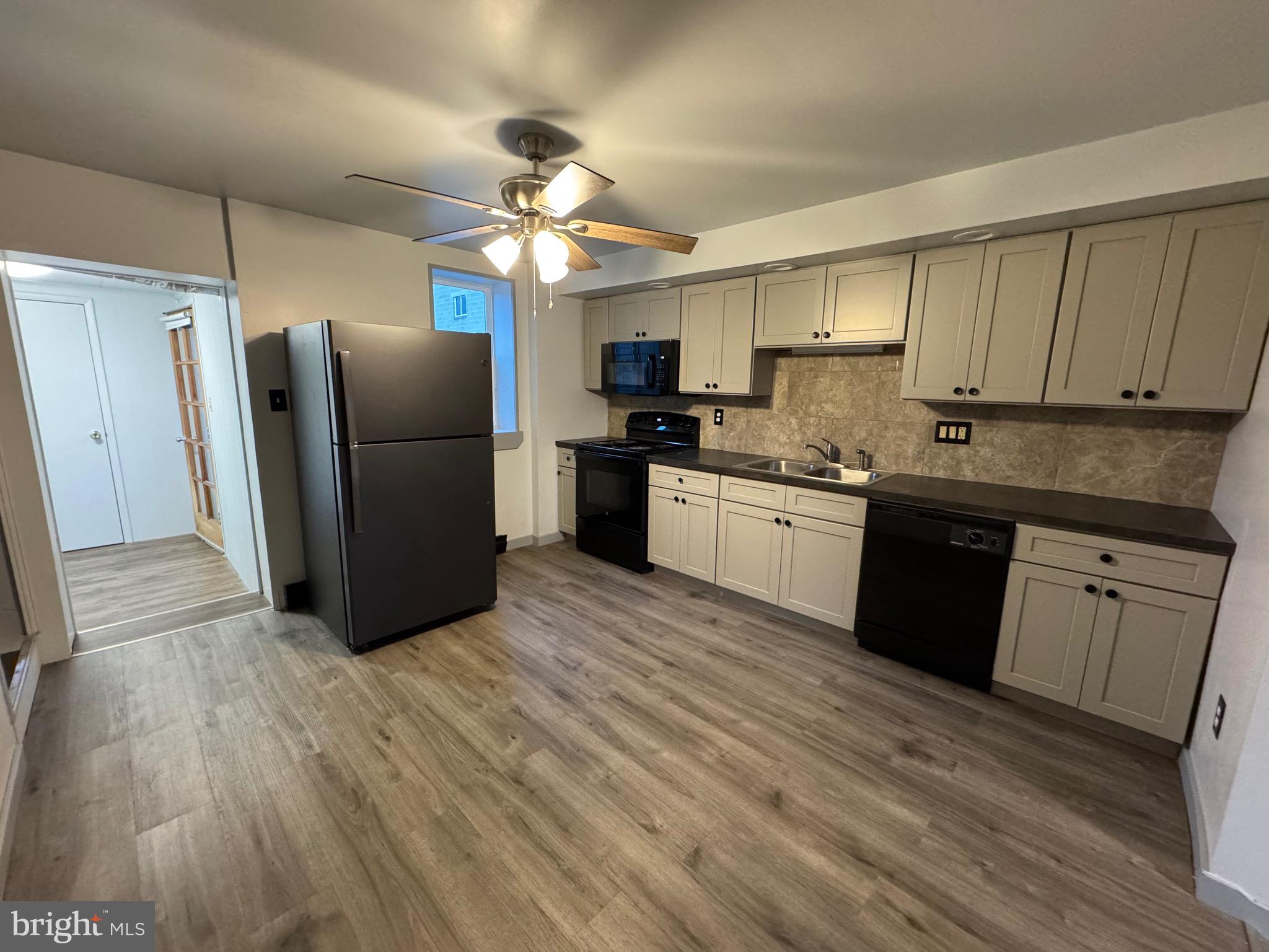 105 Spring Garden Street Leesport, PA 19533 - Photo 15 of 16 a kitchen with stainless steel appliances granite countertop a refrigerator a sink dishwasher a stove and white countertops with wooden floor