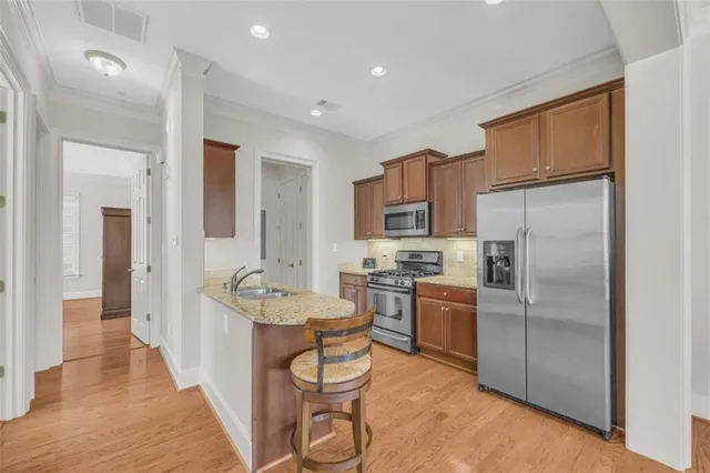 a kitchen with stainless steel appliances granite countertop a sink stove and refrigerator