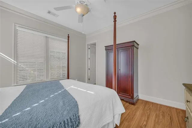 a bedroom with a large bed and wooden floor