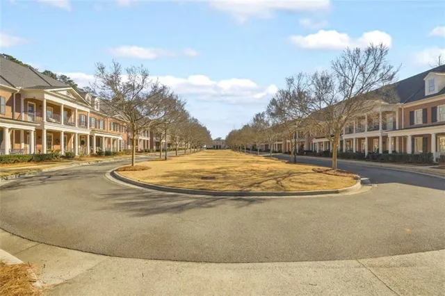 a front view of a house with a yard and potted plants