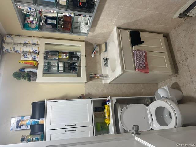 104-29 Roosevelt Avenue Queens, NY 11368 - Photo 16 of 23 a bathroom with a toilet sink and mirror