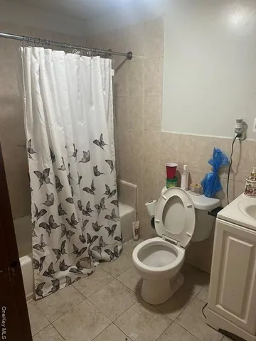 a white toilet sitting next to a shower curtain