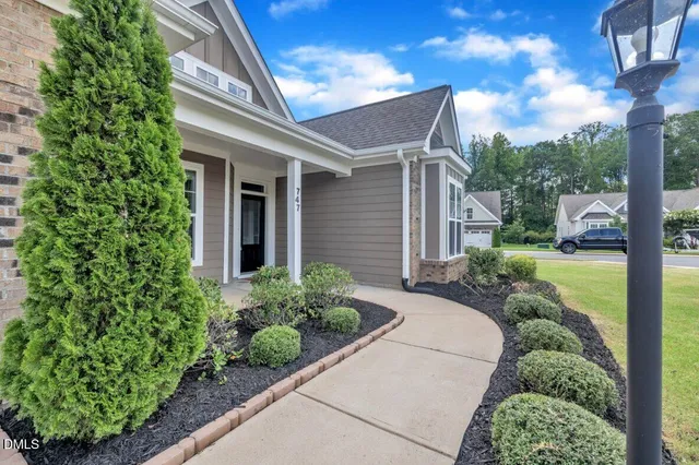 a large kitchen with granite countertop a sink and white cabinets