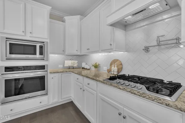 a kitchen with kitchen island granite countertop a sink a center island and stainless steel appliances