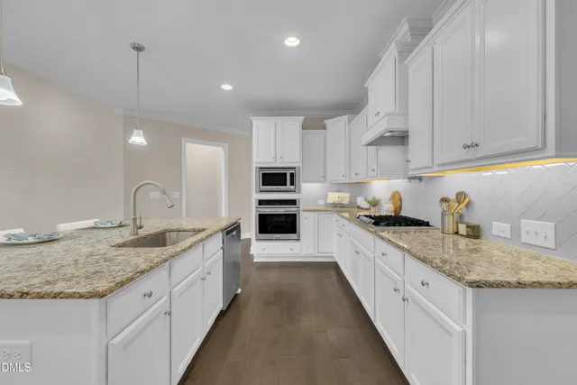 a view of an empty room with wooden floor fireplace and a window