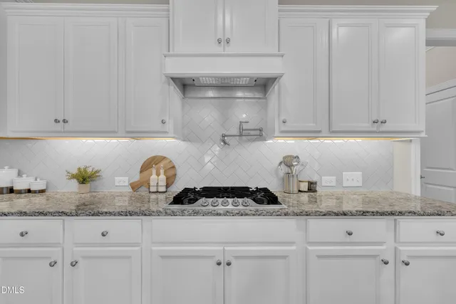 a view of a room with wooden floors chandelier and windows